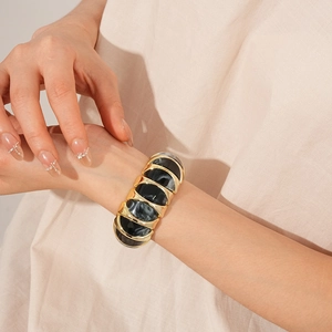 Macro shot of vintage gold elastic bracelet with marbled diamond-shaped resin inserts