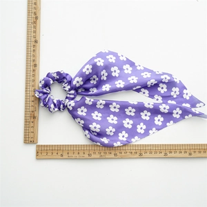 Detailed view of purple floral satin hair tie with ribbons and measurement rulers