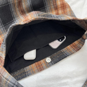 Detail of wool plaid tote bag with silver magnetic clasp and interior pocket