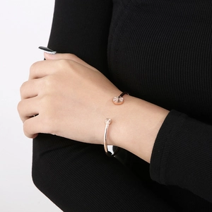 Rose gold adjustable cuff bracelet with circular engraved details on a woman's wrist