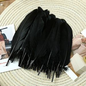 Macro detail of natural black goose feathers bunch on a woven mat for DIY craft decor