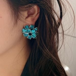 Vintage style geometric blue zircon flower stud earrings worn by a model in soft light