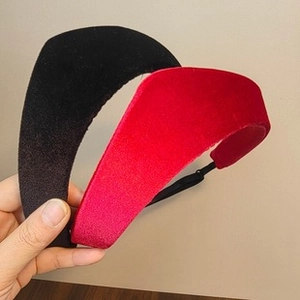 Close-up of black and red velvet wide headband with knotted detail showing soft texture