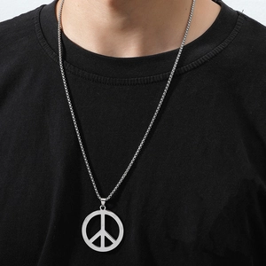 Silver stainless steel peace sign pendant necklace shown on a model in a trendy hip-hop style