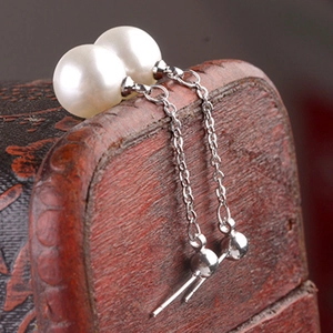 Silver drop earrings featuring elegant long chain tassels and white round pearls on a vintage box
