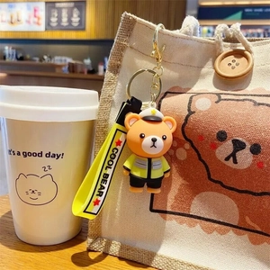 Cute orange police bear keychain with yellow vest and Cool Bear strap on a canvas bag