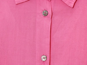Close-up detail of pink button-down shirt collar and four-hole buttons on placket