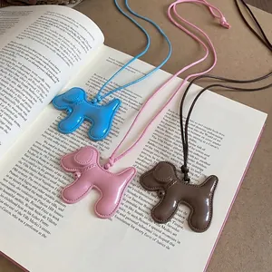 Colliers avec pendentifs chiots mignons en bleu rose et marron sur un livre ouvert