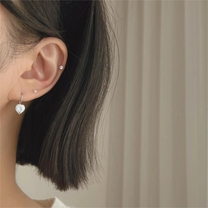 Minimalist 925 sterling silver heart earrings and cubic zirconia studs on model ear
