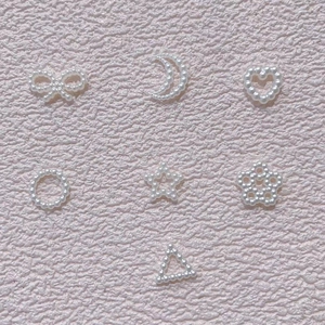 Mix of white faux pearl charms in heart, star, and bow shapes for nail art and DIY