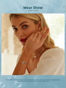 Dettaglio del bracciale doppio in argento S925 con ciondolo a conchiglia azzurra sul polso