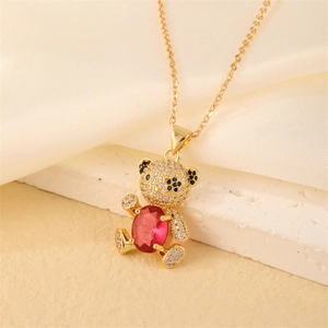 Close-up of gold bear pendant with red heart stone and pavé crystal detailing