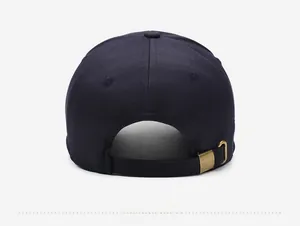 Rear view of navy blue cotton baseball cap with adjustable brass metal buckle strap