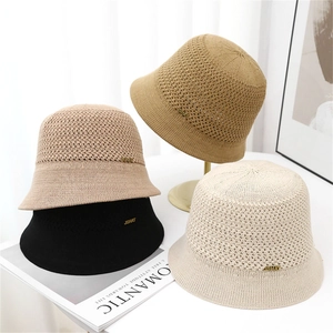 Knitted fisherman bucket hats for women in four neutral colors with gold brand tags