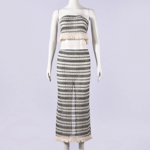 Détail d'un ensemble bohème en tricot avec haut rayé et jupe longue à pompons