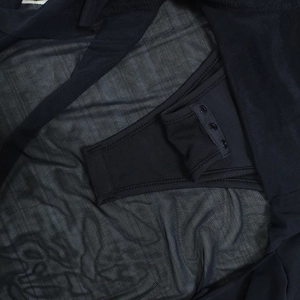 Close-up of three bottom snap buttons on ribbed knit and sheer mesh bodysuit