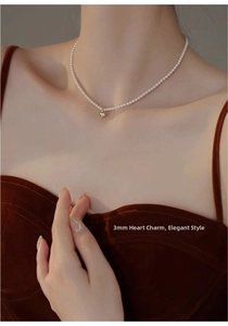 Elegant 3mm freshwater pearl choker with a gold heart pendant shown on model neck