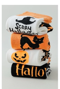 Detail view of four Halloween crew socks with pumpkin, cat, and witch hat knit patterns