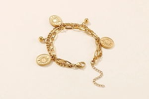 Detail of double-layer stainless steel bracelet with sun and moon oval charms