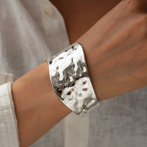 Detail of silver hammered open cuff bracelet showing rippled liquid metal texture