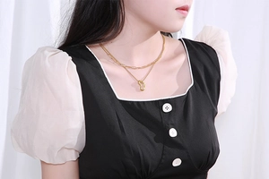 Close-up of double-layer gold chain necklace with irregular geometric pendant on model
