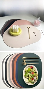 Detail of oval PU leather placemats showing heat-resistant lychee texture in various colors