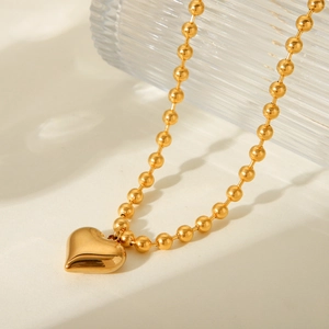 Detailed view of an 18K gold plated stainless steel beaded chain with heart pendant