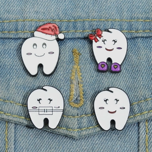 Set of 4 cute tooth enamel pins with Christmas hats on denim jacket pocket