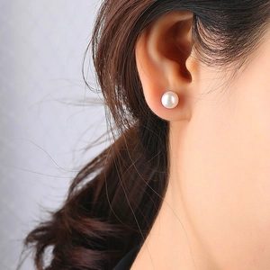 Close-up of a model wearing a small white freshwater pearl stud earring in S925 silver