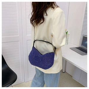 Blue rhinestone hobo bag with silver chain strap shown in a lifestyle office setting