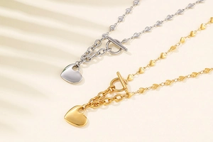 Detail of silver and gold heart link necklaces featuring OT toggle clasps and pendants
