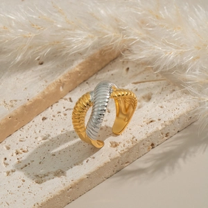 Macro detail of two-tone braided textured ring with gold and silver twisted bands