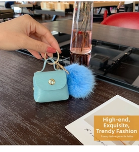Detailed view of mini light blue faux crocodile leather bag keychain with fluffy fur pom