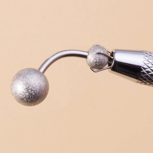 Detail of silver piercing tool with anti-slip handle and bead holder claw for body jewelry