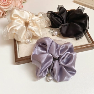 Detailed shot of satin organza scrunchies with pearls and crystals in a display tray