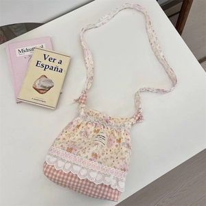 Detail of floral crossbody bag with heart lace, checkered patterns and thin shoulder strap