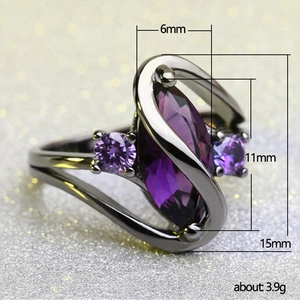 Macro side view of purple marquise-cut zircon ring with black plated metal and glitter background
