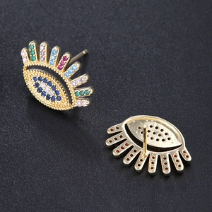 Golden evil eye earrings with colorful zircons and pin design on black background