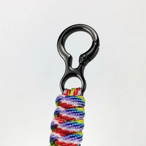 Gros plan sur le crochet pivotant en métal noir avec lanière en paracorde tressée multicolore