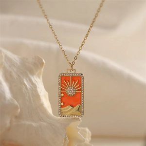 Macro view of gold tarot sun pendant with colorful zircon stones and orange enamel inlay