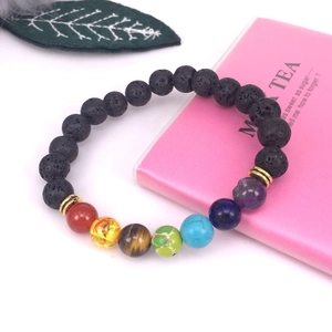 Detalle macro de pulsera de yoga chakra con piedra de lava negra y cuentas de colores