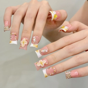 French style press-on nails with 3D floral petals, pearls, and crystals on a pink base