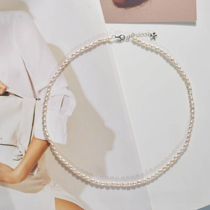 Detail view of natural freshwater rice pearl necklace with elegant silver flower clasp