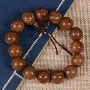 Detailed close-up of sandalwood prayer beads with traditional brown Chinese knot tassel