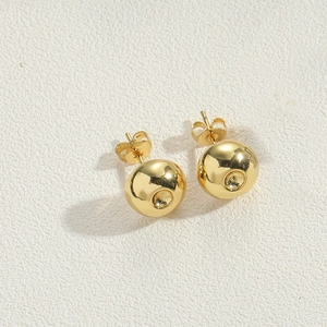 Macro shot of 14K gold plated ball stud earrings with butterfly backs on white surface