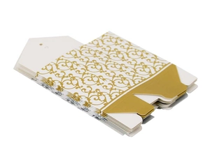 Detail of stacked white and gold gift boxes featuring vintage bronzed floral patterns