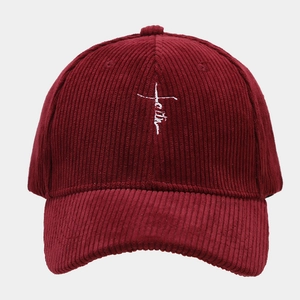 Détail de la broderie blanche faith et croix sur casquette en velours côtelé bordeaux