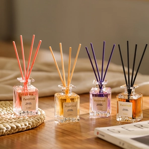Set di quattro diffusori di fragranze colorate in bottiglie di vetro su legno