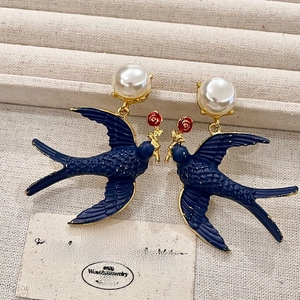 Detail of vintage blue enamel swallow earrings with red rose and pearl studs