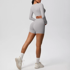 Light gray yoga set featuring long sleeve cropped top and high waist shorts from side view